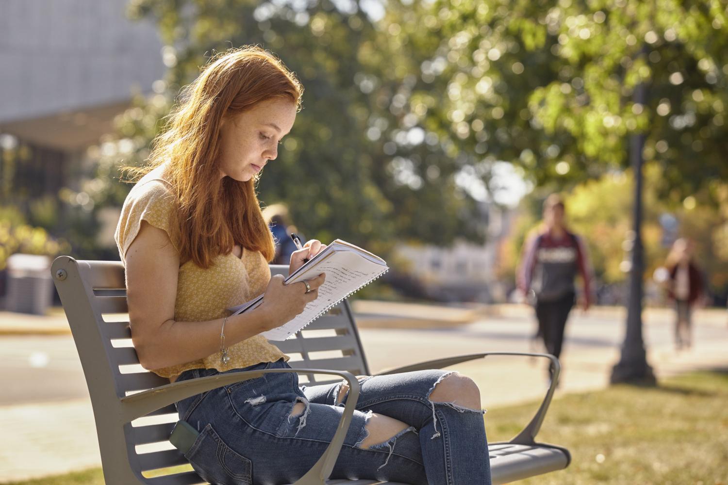 一位<a href='http://mecvnu.v6pu.com'>全球十大赌钱排行app</a>学院的学生在校园里的长椅上读书.